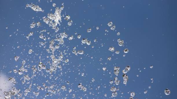 istock Water sprayed under pressure from fountain under blue sky, water movement closeup abstract backdrop. 1417684696