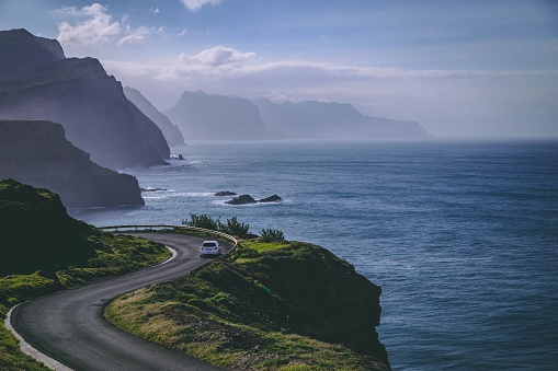 An aerial view of a car on a road near the cliff in Canical, Madeira Island, Portugal