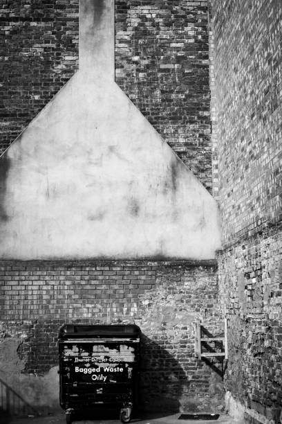 istock Grayscale shot of bagged waste basket against an old brick wall 1417685570