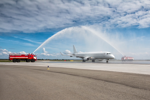 Water arch for first visit white passenger jet plane at the airport