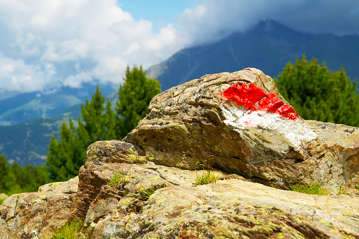 Pile of rocks with a direction marker on it in the the alps of south tyrol
