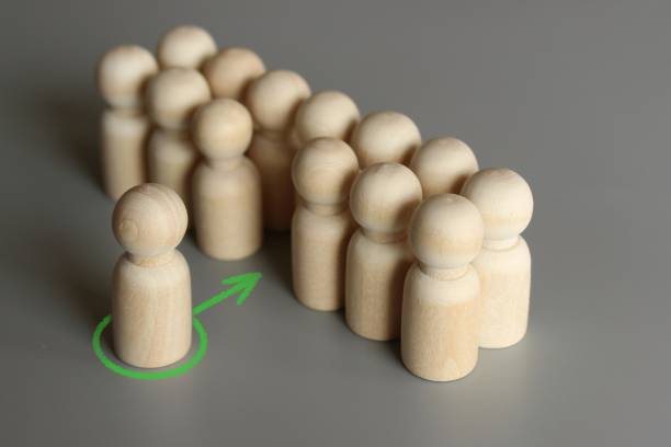 istock Selective focus image of one wooden doll join the group 1417692213