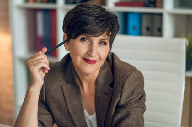 istock Pretty mature woman smiling nicely and looking positive 1417695448