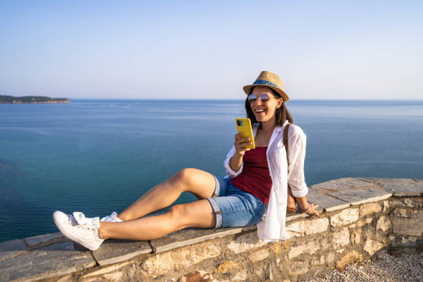 istock A young woman is using the phone at the sea 1417696617