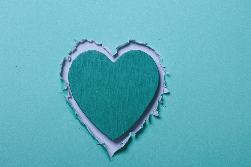 A heart-shaped  hole in a green paper