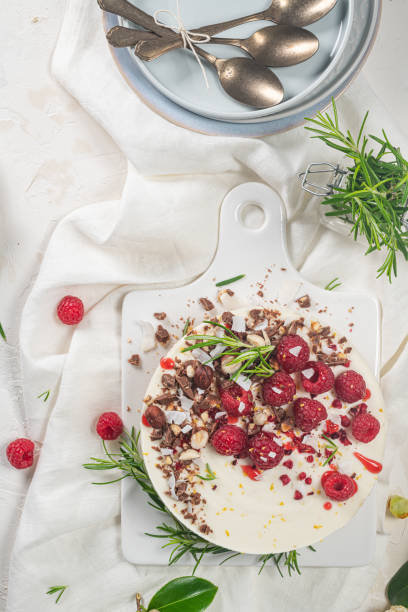 istock Cheesecake with raspberries, chocolate, hazelnuts and rosemary leaves on kitchen coutertop 1417700001