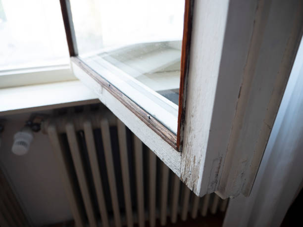 old window frames, old worn wooden window, with radiator in the background, obsolete windows stock photo