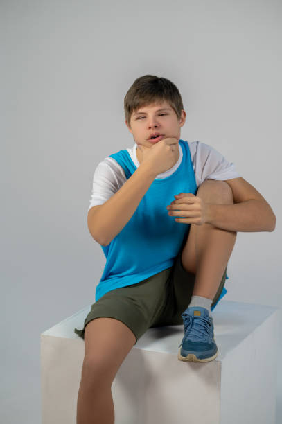 istock A boy in a blue thsirt sitting with a bored look 1417710135