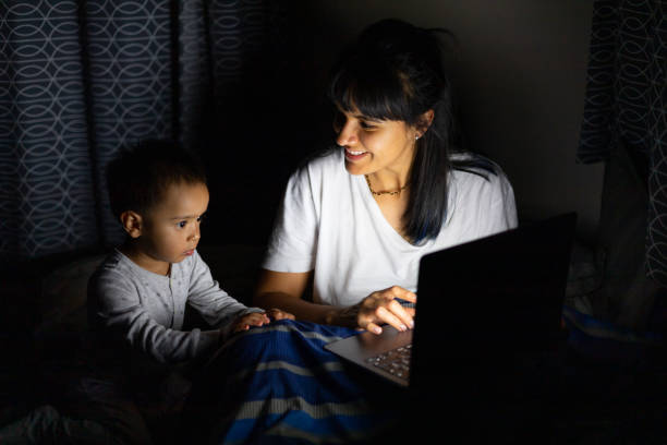 istock Woman and her child watching a screen at night 1417712490