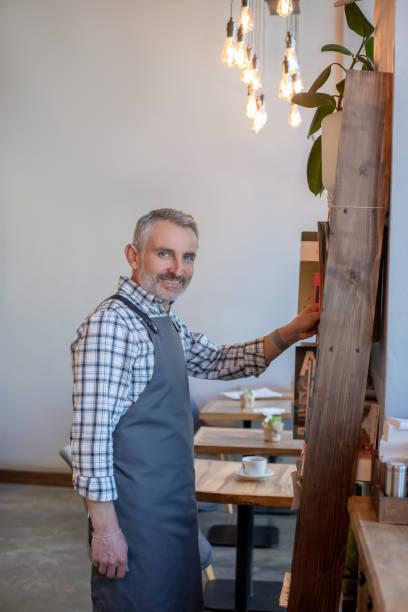istock Cafe owner in a cafe standing near the tables 1417715049