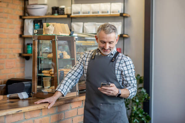 istock Cafe owner standing near the counter and looking contented 1417715081