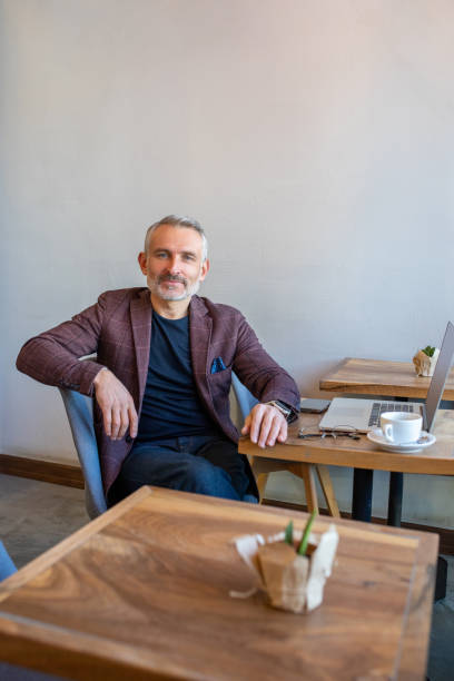 istock Confident man in jacket sitting in a cafe and looking in camera 1417715084