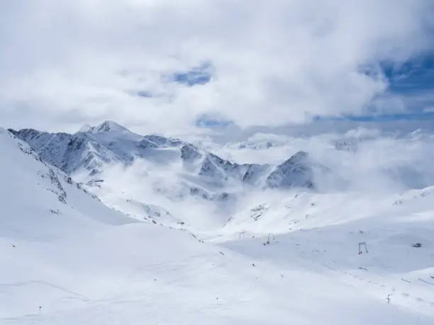 Winter landscape with snow covered mountain slopes and empty pistes, spring sunny day at ski resort Stubai Gletscher, Stubaital, Tyrol, Austrian Alps