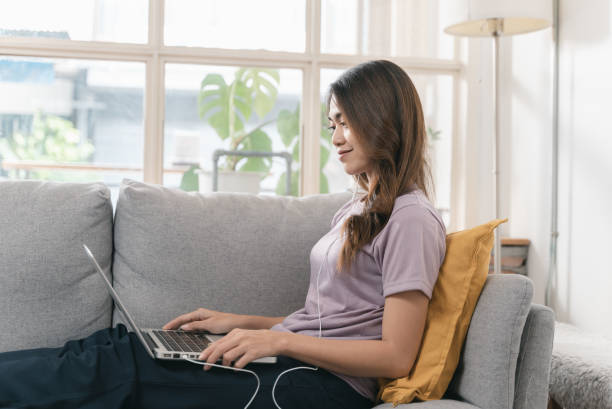 istock Attractive young Asian woman looking at laptop while studying from home 1417717204