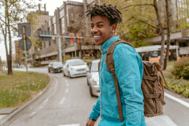 istock Guy smiling at camera crossing road in city 1417720855