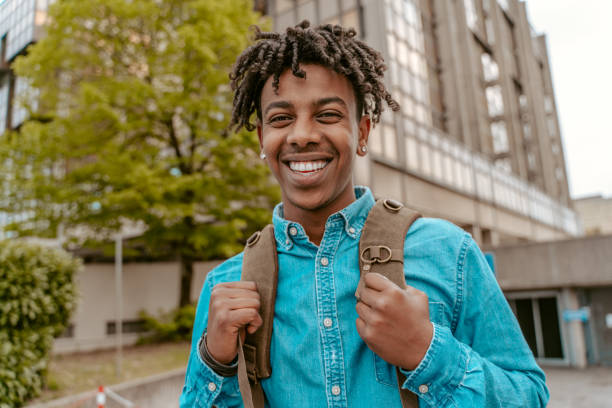 istock Guy smiling at camera standing on city street 1417720858