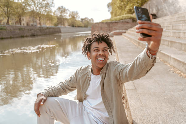 istock Guy taking selfie on smartphone near water 1417721397