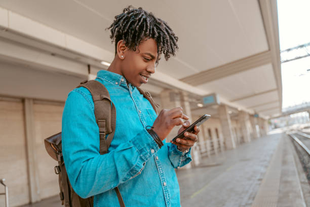 istock Guy looking at smartphone waiting for arrival of train 1417721487