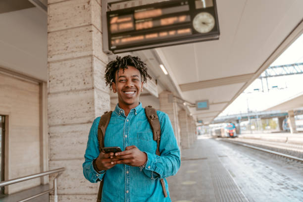 istock Guy with smartphone smiling at camera near railway 1417721520