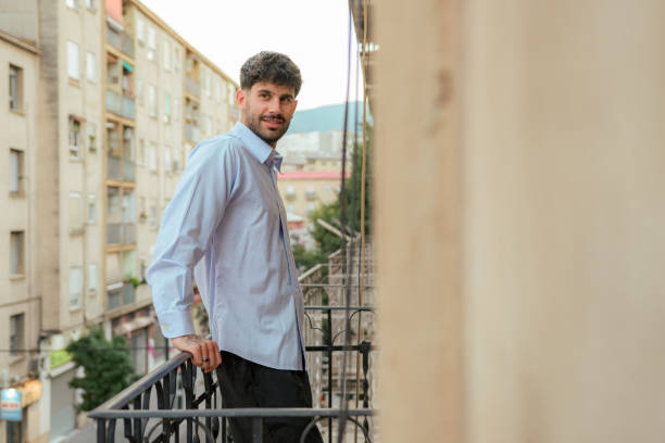 istock Happiness man smiles and poses in a balcony 1417721573