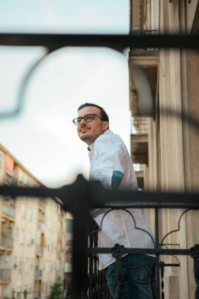 istock Happiness man smiles and poses in a balcony 1417721596
