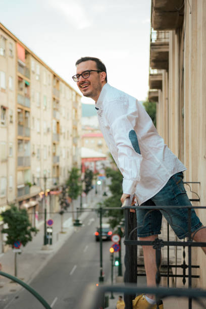 istock Happiness man smiles and poses in a balcony 1417721599