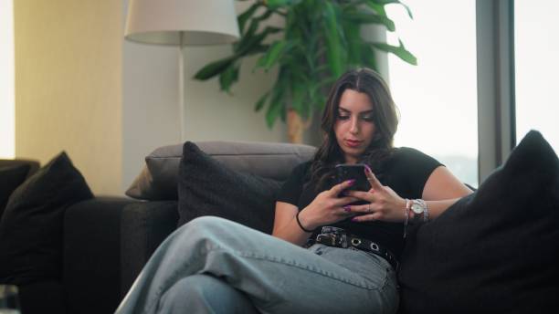 istock Young woman using smart phone at home 1417725889