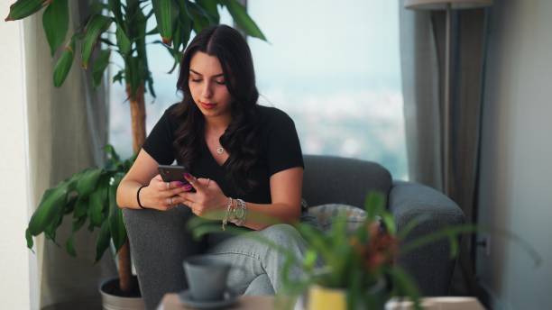 istock Young woman using smart phone at home 1417726066