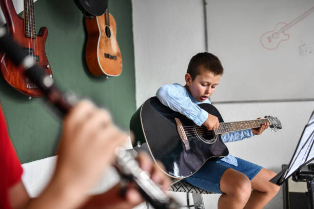 istock Guitar Student Accompanying Clarinet Playing Friend In Classroom 1417726292