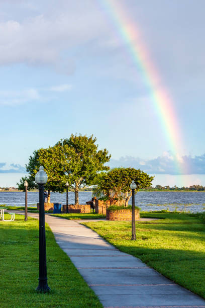 Lake Tohopeliga in Kissimmee Florida has a unique Lighthouse Jetty at the northern shoreline - which is much enhanced following a brief afternoon shower that provided this perfect Rainbow. stock photo