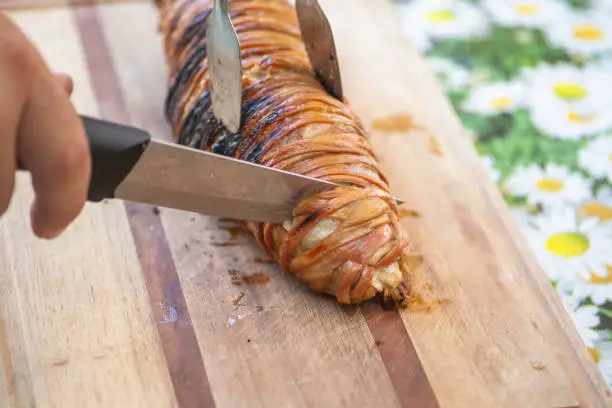 View of a rolled kokorec on cutting board.

Kokorec is a dish of the Balkans and Asia Minor, consisting of lamb or goat intestines wrapped around seasoned offal, including sweetbreads, hearts, lungs, or kidneys, and typically grilled; a variant consists of chopped innards cooked on a griddle. The intestines of suckling lambs are preferred.