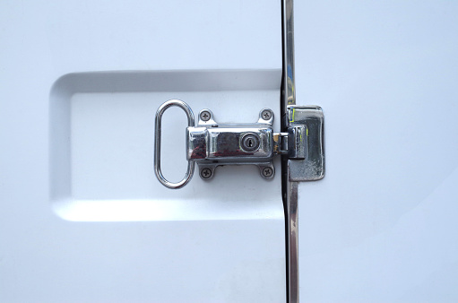 Closed white refrigerated truck door lock closeup