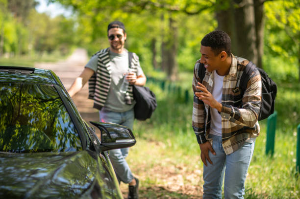 istock Young men stopping the car on the forest road 1417731818