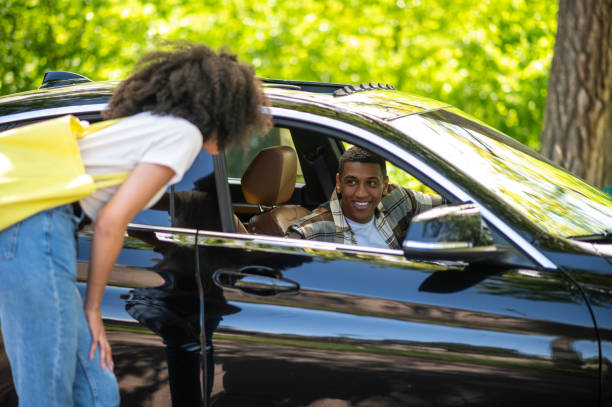 istock Hitchhiker talking to a car driver on the road 1417731893