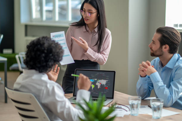 istock Long-haired brunette talking with business partners in the office 1417742049