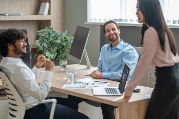 istock Long-haired brunette talking with business partners in the office 1417742084
