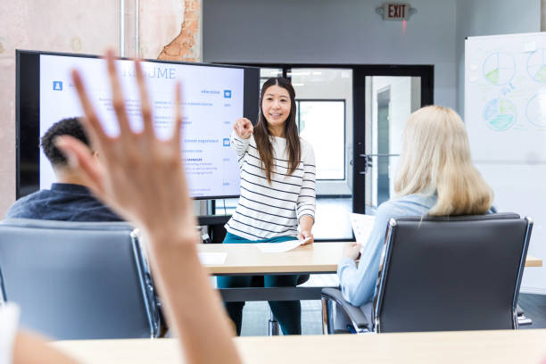 istock Mid adult teacher points to unrecognizable student with raised hand 1417742133