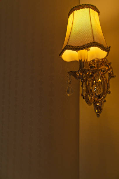 Sconce wall lamp in orange color in the apartment room or bedroom. Free space for text