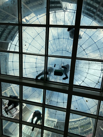 Cleaners on the glass ceiling inside the shopping center. The shopping center is inside one of the Vienna gasometers (former gasholder houses built in 1896 to 1899, which were converted for modern use in 2001).