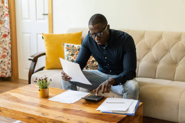 A man calculating his home finances stock photo