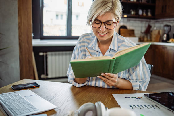 istock Smiling businesswoman taking notes while working at home 1417752726