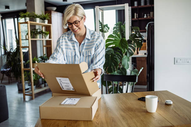 istock Blonde woman is looking with curiosity in her delivery package. 1417752730