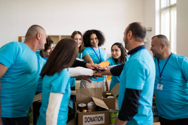 A circle of aid workers celebrating by stacking their hands together
