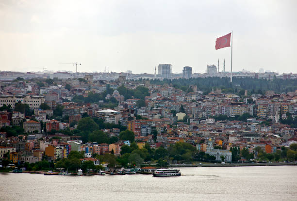 Istanbul,Turkey - August 10, 2022: Galata bridge linked eminönü and karaköy, there are lots of people on the bridge, lots of them are fishing, and beyond the bridge you see the golden horn view with ottoman mosques in a cloudy summer day.