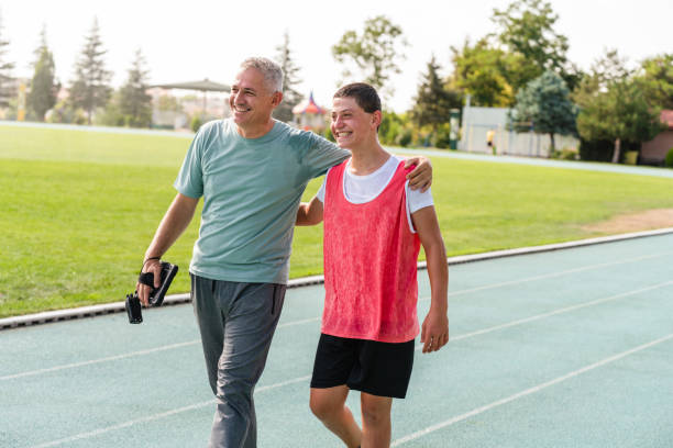 trener rozmawia z nastoletnimi sportowcami - teacher preparation two people teamwork zdjęcia i obrazy z banku zdjęć