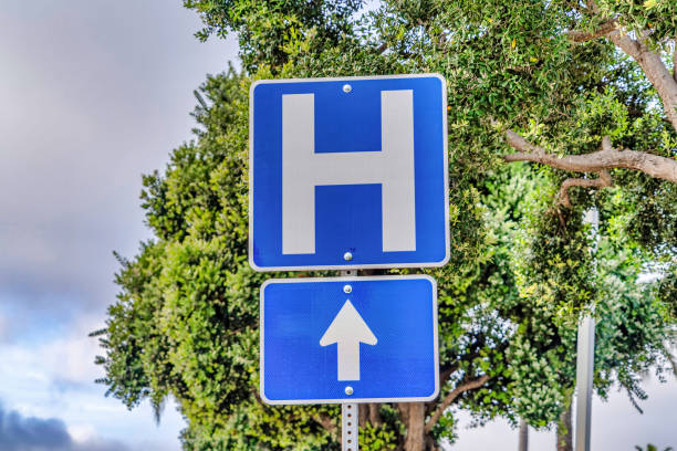 znak drogowy z tłem drzewa i nieba przez duże h dla kierunku szpitala - road sign sign blue blank zdjęcia i obrazy z banku zdjęć