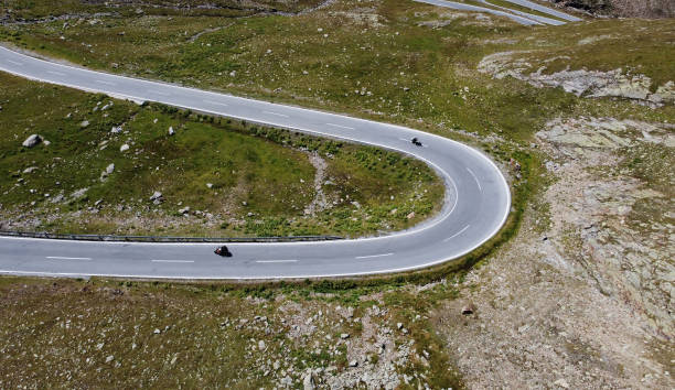 山の中のオートバイとのタイトなカーブの空中ドローンショット - ötztal alps ストックフォトと画像