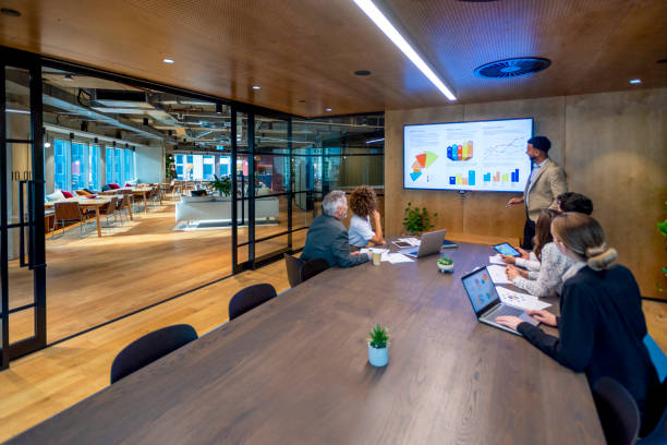 istock Man giving a big data presentation on a tv in a board room. 1417762254