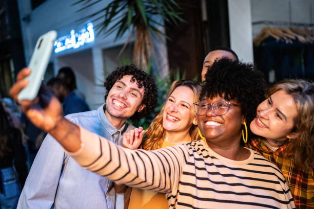 istock Friends taking a selfie or filming using mobile phone outdoors 1417765572