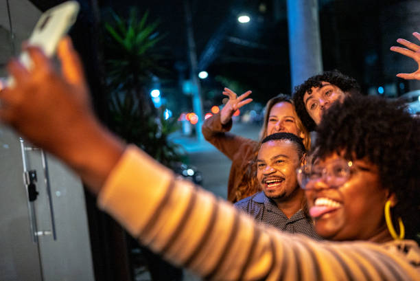istock Friends taking a selfie or filming using mobile phone outdoors 1417765629